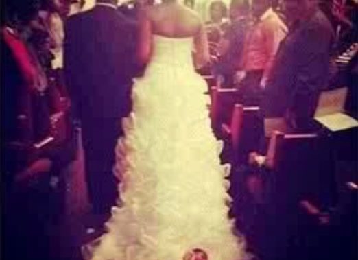 bride drags baby down the aisle attached to dress